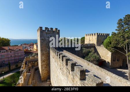 Die umliegenden Mauern und Türme des historischen Castelo de Sao Jorge (Castelo de Sao Jorge) in Lissabon, Portugal, an einem sonnigen Tag. Stockfoto