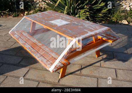 Picknicktisch mit Plastikfolie bedeckt, um die Sperrung während der Coronavirus-Pandemie Covid-19 in Europa zu erzwingen Stockfoto