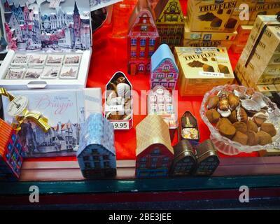 Fenster eines Schokoladenladens, in dem Trüffel, Pralinen, Statuen und andere Schokoladenartikel in Brügge, Belgien, verkauft werden Stockfoto