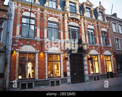 Fassade eines typisch flämischen Gebäudes aus roten Ziegeln und weißen gerahmten Fenstern in Brügge, Belgien Stockfoto