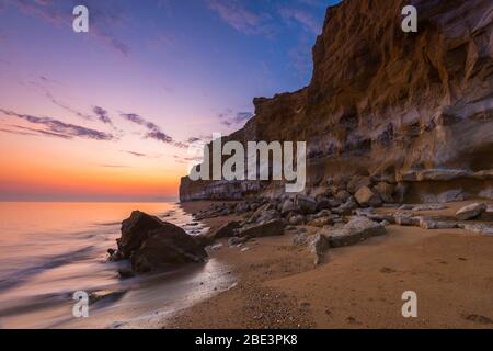 Burton Bradstock, Dorset, Großbritannien. April 2020. Wetter in Großbritannien. Die senkrechten Sandsteinklippen am Hive Beach am Burton Bradstock in Dorset am Ende eines heißen sonnigen Tages. Bild: Graham Hunt/Alamy Live News Stockfoto