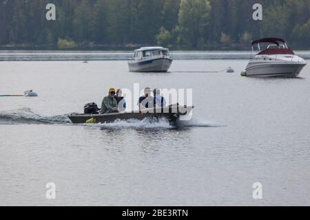 Grand Teton National Park, Wyoming / USA - 17. Juli 2014: Vier Männer in einem kleinen Boot kommen in Coulter Bay Marina am Jackson Lake im Grand Teton Stockfoto