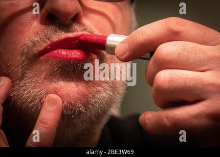 Reifer Mann, der Lippenstift auf seine Lippen anwendet. 40-44 Jahre alt, 45-49, 50-54, 54-59, Stockfoto