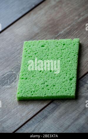 Zellulose Schwamm Küche Objekte auf dem Holz Textur Hintergrund. Zellulose Serviette auf dem Tisch. Stockfoto