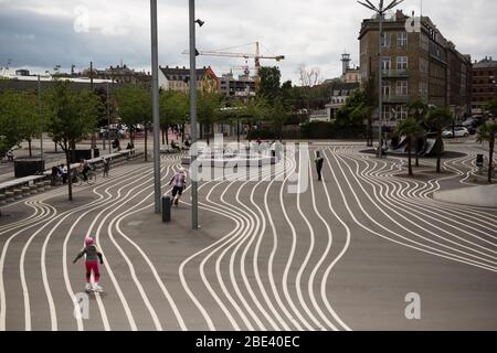 Fahrradfahren und Rollladen sind beliebte Aktivitäten im modernen Park Superkilen im Nørrebro-Viertel von Kopenhagen, Dänemark. Stockfoto