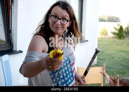 Mama neckt jungen Sohn, indem sie dem Fotografen zuerst eine Tasse Brezeln anbietet. Zawady Gmina Rzeczyca Polen Stockfoto