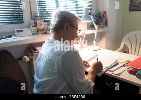Arzt für Ohren, Nase und Hals, der ein Rezept für eine Patientin in ihrem Home Office schreibt. Skierniewice Polen Stockfoto