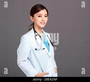 Lächelnd asiatische Frau Arzt in weißen Mantel Stockfoto