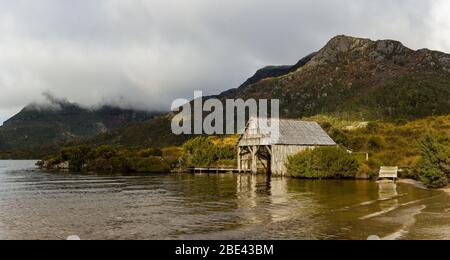 Ikonische Aussicht auf der Promenade, die zum hölzernen Bootshaus am Dove Lake führt, im Cradle Mountain National Park in Tasmanien, Australien. Stockfoto