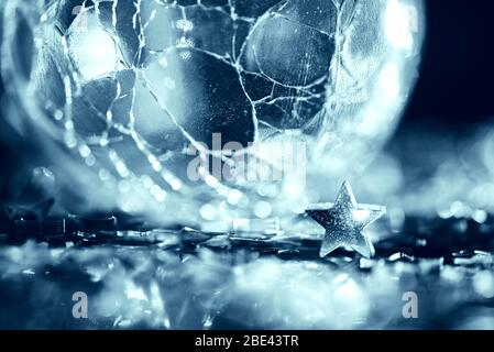 Makro-Foto von hellen silbernen Stern und rissige Glaskugel mit Licht Bokeh Stockfoto