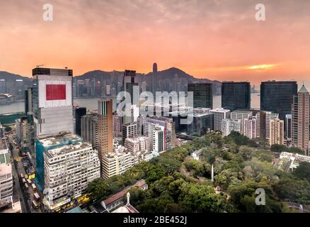 Panorama-Dachansicht der Tsim Sha Tsui Skyline unter einem lebendigen Sonnenuntergang in Kowloon, Hongkong Stockfoto