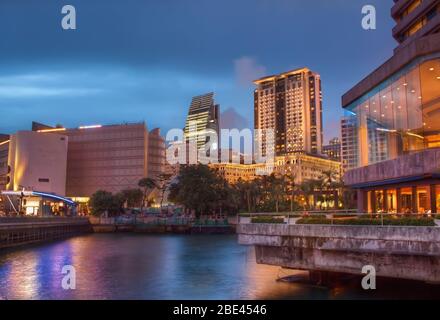 Moderne Luxushotels mit bunten Reflexionen unter Magenta Sunset in Kowloon, Hongkong Stockfoto