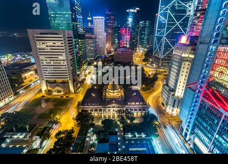 Dachterrasse mit Blick auf die futuristische Skyline und die Stadt bei Nacht mit lebhaften Lichtern, Hongkong Stockfoto