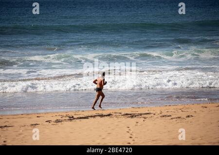 Bilgola Beach Sydney, Australien. Ostersonntag 12. April 2020. Die Zahl der Todesopfer in Australien beträgt 57, die Einwohner von Sydney haben die Anforderungen für den Aufenthalt zu Hause erfüllt, die Pools am Strand sind geschlossen, die offenen Strände werden genutzt, um eine kleine Anzahl von Bewohnern zu Fuß, joggen oder surfen zu gehen. Credit Martin Berry/Alamy Live News Stockfoto