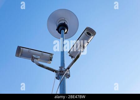 Zwei Überwachungskameras gegen blauen Himmel Stockfoto