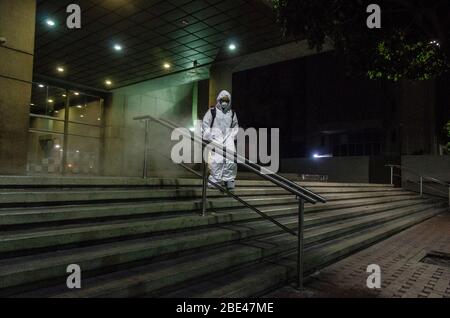 Reinigungspersonal zu Fuß desinfizieren einen Platz und Straßen. Tag der Nacht Reinigung und Desinfektion in den Straßen von Caracas, Venezuela, um die spr Stockfoto