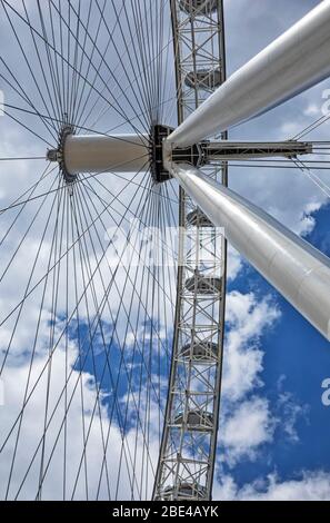 Blick von direkt unter den Kabeln und Schoten des London Eye mit blauem Himmel und Wolken im Hintergrund; London, England Stockfoto