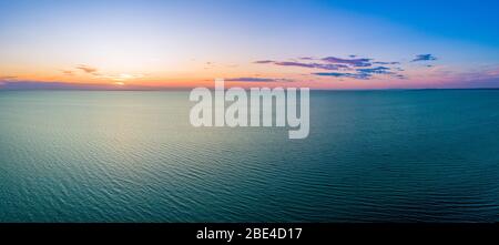 Breites Luftpanorama des Sonnenuntergangs über dem Ozean mit Kopierraum Stockfoto