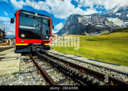 Beliebte Zahnrad rote Bahn in der Bergbahn Bahnhof geparkt. Touristenzug in der Bergstation kleine Scheidegg, Grindelwald, Berner Ober Stockfoto