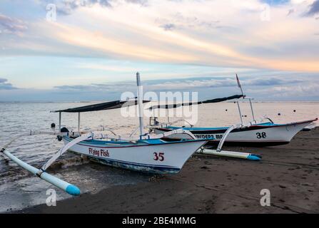 Horizontale Ansicht der Ausleger am Strand von Lovina in Bali bei Sonnenaufgang, Indonesien. Stockfoto