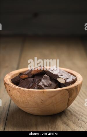 Hausgemachte dunkle Schokolade mit Mandeln in Holzschale Stockfoto