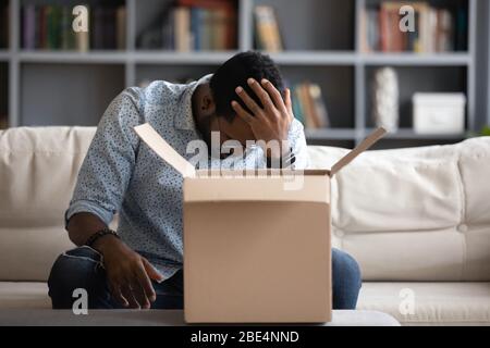 Betonte junge multirassische Mann, die verzweifelt über die Bestellung eines falschen Artikels waren. Stockfoto