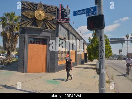 Los Angeles, USA. April 2020. Eine Frau geht am Samstag, den 11. April 2020, an einem vernagelten Café in der Nähe der Kreuzung von Hollywood und Sunset vorbei. Viele kleine Restaurants kämpfen darum, offen zu bleiben, und die staatlichen und lokalen Richtlinien besagen, dass sie nur nach der Coronavirus-Pandemie einen Take-out-Service anbieten. Foto von Jim Ruymen/UPI Quelle: UPI/Alamy Live News Stockfoto