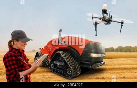 Farmerin mit digitalem Tablet steuert einen autonomen Traktor und eine Drohne auf einem intelligenten Bauernhof Stockfoto