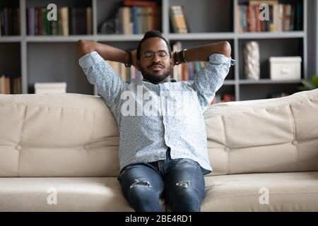 Junger friedlicher birazialer Mann, der auf einem bequemen Sofa schläft. Stockfoto