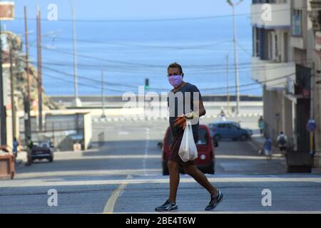 Havanna, Kuba. April 2020. Ein Mann mit einer Maske ist auf der Straße in Havanna, Kuba, am 11. April 2020 zu sehen. Die kubanische Regierung hat seit Samstag begonnen, den öffentlichen Verkehr als vorbeugende Maßnahme gegen COVID-19 auszusetzen. Kuba hat Maßnahmen wie die Schließung von Grenzen, die Aussetzung des Transports zwischen den Provinzen und die Schließung von Schulen ergriffen, um die Ausbreitung der Epidemie einzudämmen. Kredit: Zhu Wanjun/Xinhua/Alamy Live News Stockfoto