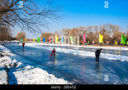 Bewohner Schlittschuhlaufen auf einem gefrorenen See im Shenyang Beiling Park, Provinz Liaoning, China. Stockfoto