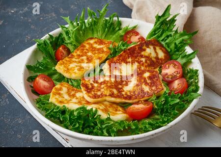 Gesunder Salat mit gebratenen Halloumi und Tomaten, Nahaufnahme, Keto ketogene Ernährung Stockfoto