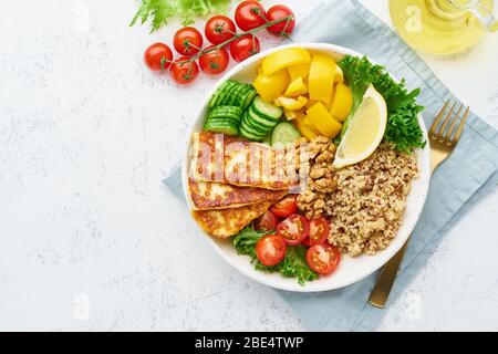 Buddha-Schüssel mit Quinoa, Halloumi, Salat, vegetarische Küche, weißer Hintergrund, Draufsicht Stockfoto