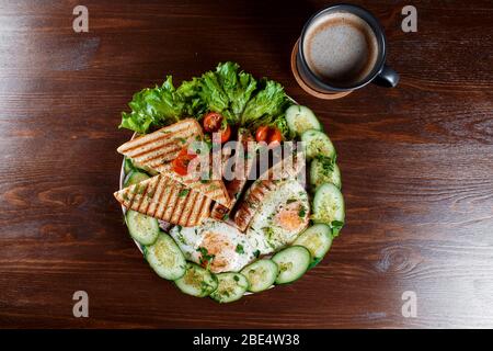 Sandwiches mit Würstchen, Dill und einem Zweig Basilikum auf einem weißen Teller auf einem Holztisch erröten. Die Idee des schnellen Kochens. Nahaufnahme. Stockfoto