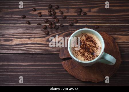 Tasse mit Kaffee auf einer ländlichen Holzplatte. Latte oder Cappuccino mit Schokoladenstreuseln. Kopierraum. Draufsicht Stockfoto