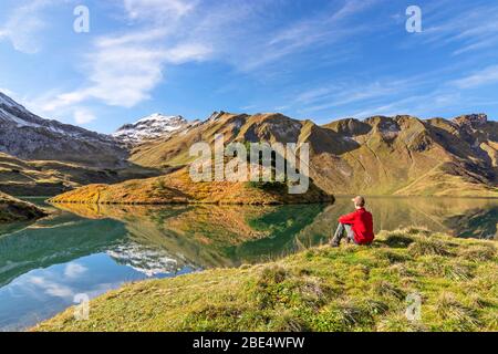 Mann sitzt an einem Bergsee. Allgäuer Alpen, Bayern, Deutschland Stockfoto