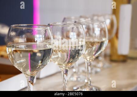 Drei Gläser mit Weißwein bleiben auf dem Tisch in der Innenaufnahme Stockfoto