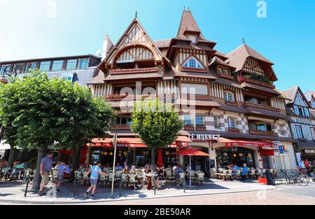 Bewohner der Stadt und Touristen entspannen sich in einem Morny's Café in einer Straße im Zentrum von Trouville . Normandie, Frankreich. Stockfoto