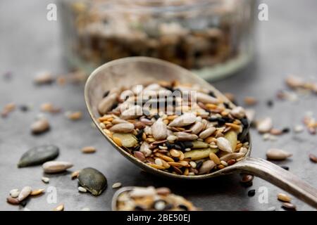 Gesunde Samen mischen sich in einem Holzlöffel aus nächster Nähe. Gesunde Lebensmittel, vegane Lebensmittelzutat. Stockfoto