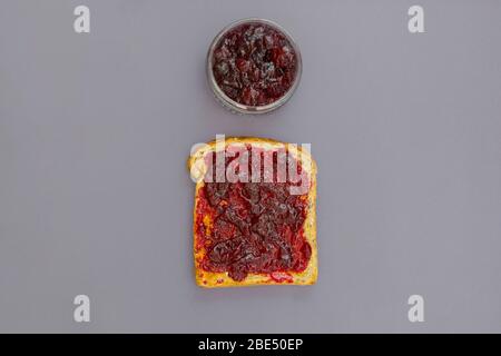 Geröstetes Brot mit Beerenmarmelade, Draufsicht. Traditionelles Frühstück. Stockfoto