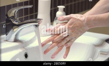 Die richtige Technik für gute Handhygiene, um sich vor den Keimen und dem Covid19 Coronavirus zu schützen. Längere Seifen, Reiben und Abwaschen der Hände mit Wasser. Nahaufnahme. Stockfoto