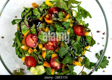 Salat aus frischem Gemüse, Tomaten, Paprika, Avocados, Gurken mit Olivenöl und Balsamico-Sauce. Das Konzept der gesunden Ernährung Lebensmittel. Nahaufnahme. Stockfoto