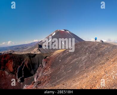 Rucksacktourist, der sich den Mt Ngauruhoe (auch bekannt als Mt Doom) und den Red Crater im Tongariro Nationalpark in Neuseeland anschaut. Stockfoto