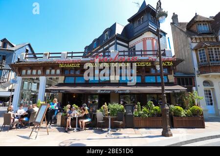 Bewohner der Stadt und Touristen entspannen sich in einem Barbara Restaurant auf einer Straße im Zentrum von Dauville. Normandie, Frankreich. Stockfoto