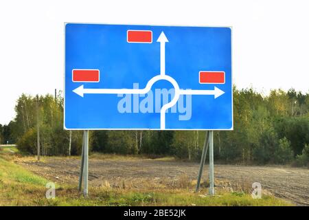 Verkehrszeichen kreisförmige Verkehrszeichen und Richtungsanzeiger, Kreisverkehr gegen den Himmel und Wald zur Information verwenden close-up Stockfoto