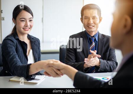 Geschäft Leute die Hände schütteln und lächelnd ihre Vereinbarung Vertrag unterzeichnen und Beenden einer Sitzung Stockfoto