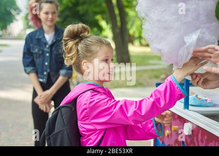 Kinder mit Zuckerwatte. Mädchen Kind kaufen rosa süßen Zucker Wolke. Stockfoto