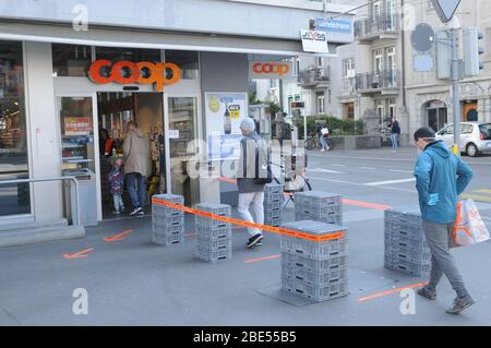 Zürich/Schweiz: Shopping in Zeiten von Covid19 Coronavirus. Draußen mit zwei Metern Abstand und beschränkter Zugangszahl von Menschen zu stehen, erlaubte ich Stockfoto