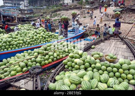 Bangladeschische Arbeiter entladen während der von der Regierung auferlegten Sperrung während des Coronavirus-Ausbruchs in Dhaka Wassermelonen an einem Dock. Menschen, die in der Lebensmittelindustrie arbeiten, sind von der Sperrregel ausgenommen.Bangladesch hat 621 Fälle bestätigt, mit 34 Todesfällen durch Coronavirus (COVID-19), so die IEDCR-Beamten. Stockfoto