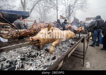 KACAREVO, SERBIEN - 18. FEBRUAR 2017: Der Mann brate auf einem traditionellen Grill Serbiens auf dem Balkan ein Schwein und ein Lamm, genannt Pecenje auf einem Markt. Por Stockfoto